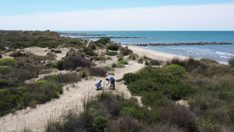 Environmental-volunteers-picking-up-plastics-and-trash-on-a-beach-espiguette